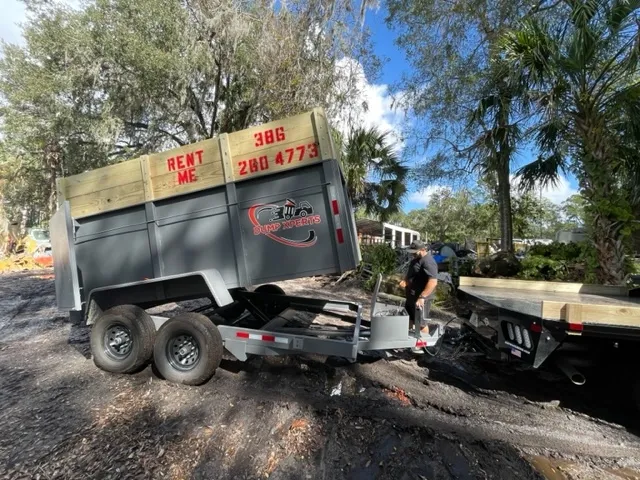 A tipping trailer and truck at a work site.