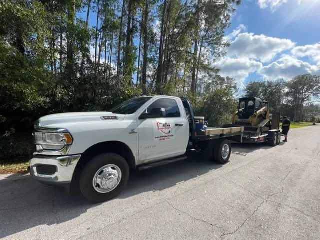 A branded work truck with site equipment on a trailer.