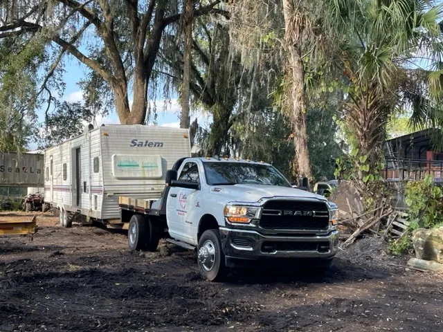Truck and trailer beside a property.